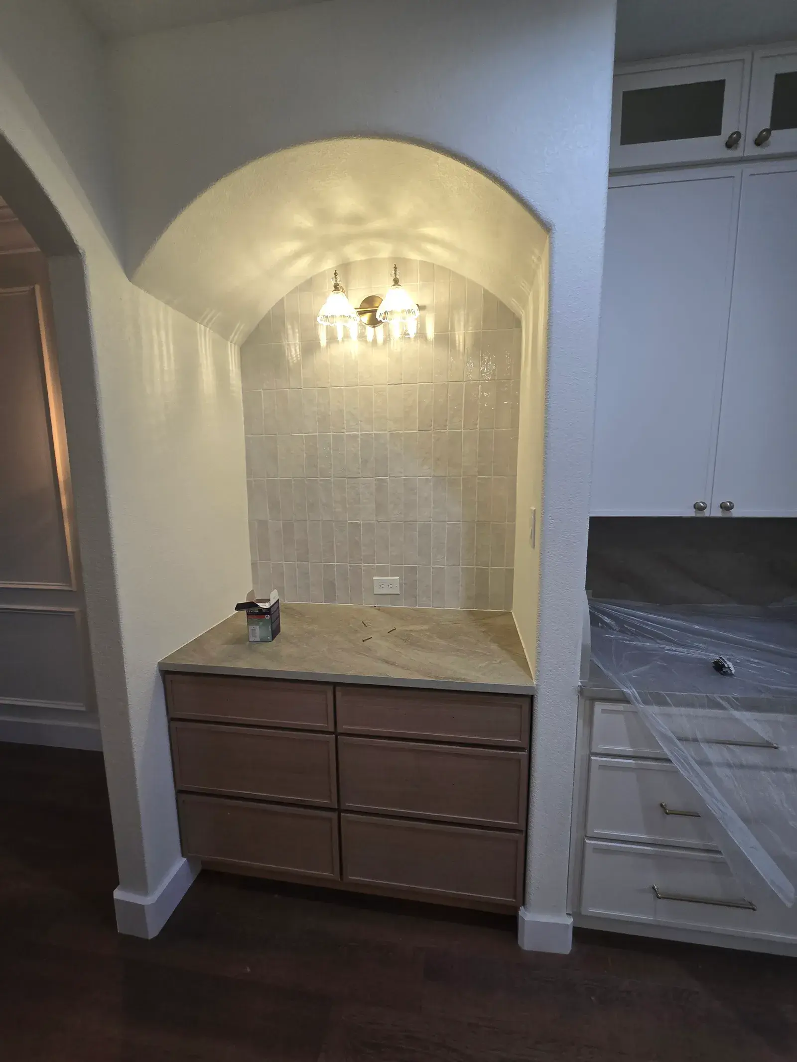 Arched bar nook with tile backsplash and wood cabinets