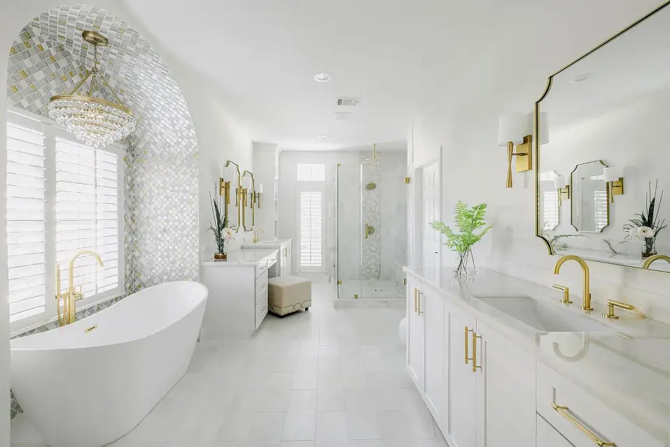Bath with a freestanding tub, brass fixtures, mosaic feature wall and large-format floor tile