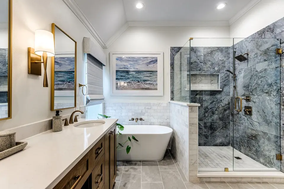 Bath with a freestanding tub, a marble-look slab shower wall and a wood vanity