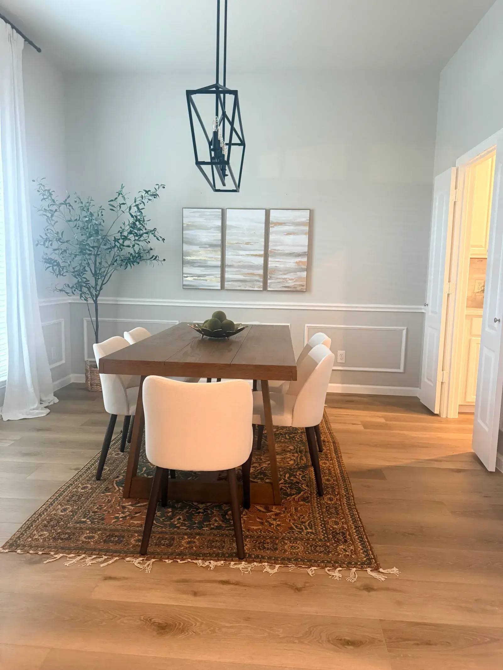 Dining room with wall panelling and wide-plank wood floor