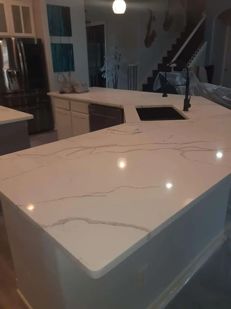 Veined quartz counter with a waterfall edge and undermount sink
