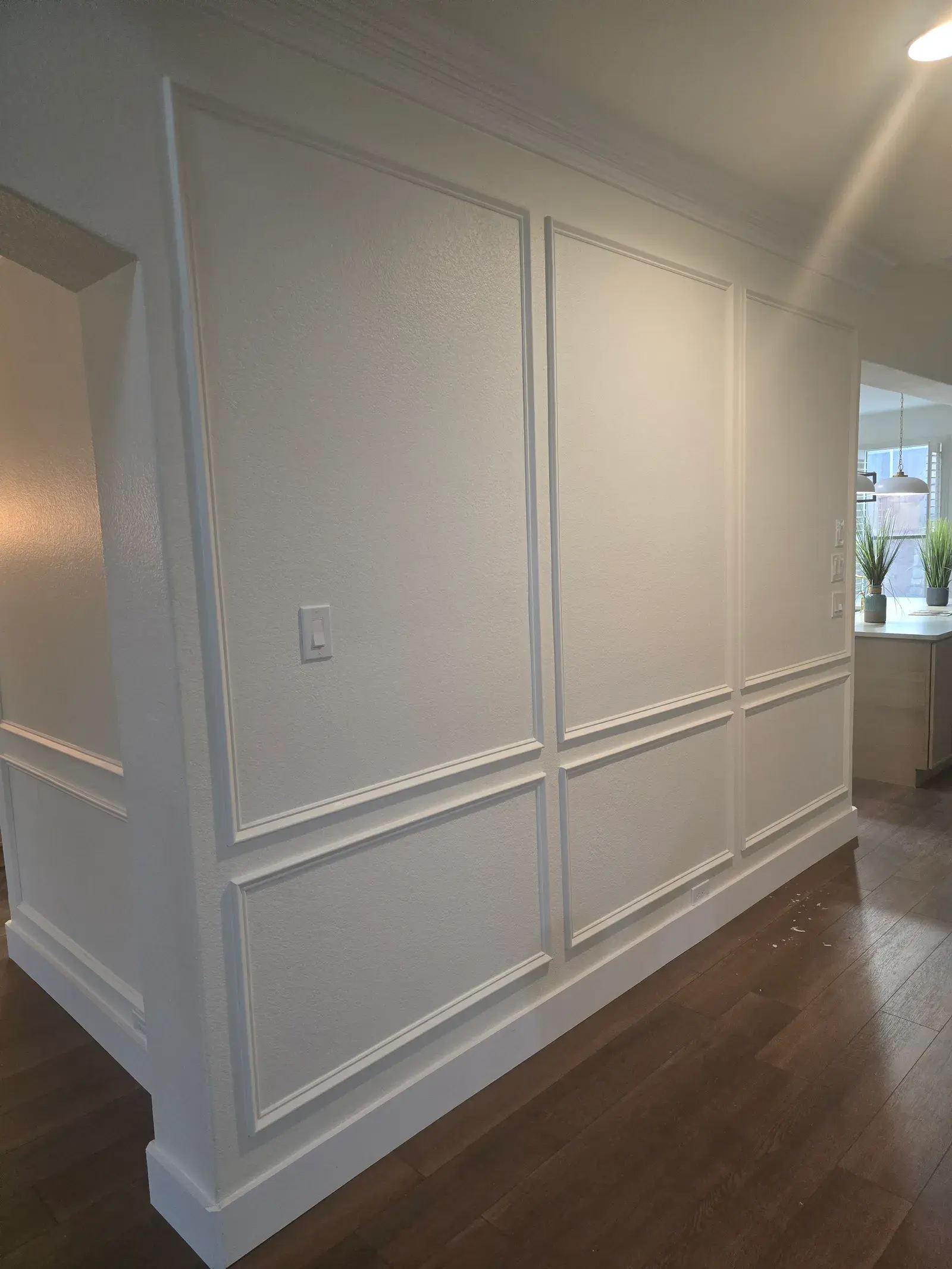 Hallway with painted wainscot panelling and wood floor